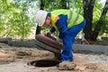 The worker opened the plastic cover of the hatch of urban communications