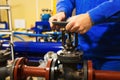 Worker opens valve on pipeline at industrial plant Royalty Free Stock Photo