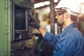 Worker operate CNC machine with G-Code monitor, high skill labor work industry with safety clothes Royalty Free Stock Photo