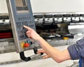 Worker operates bending machine in a metal construction company