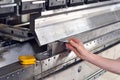 Worker operates bending machine in a metal construction company