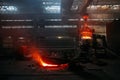 Worker operates metal casting process in metallurgical plant