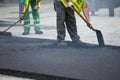 Worker operating asphalt paver machine