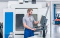 Worker operating computer-controlled machine tool Royalty Free Stock Photo