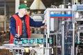 Worker operating conveyor or labeling machine at factory Royalty Free Stock Photo