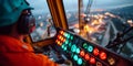A worker operating a crane at night with lights in the background Royalty Free Stock Photo