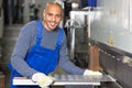 Worker operating machine for bending sheet metal Royalty Free Stock Photo