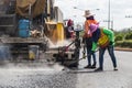 Worker operating the process of building new asphalt road on the