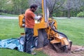 Worker operating a stump grinder