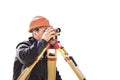 A worker in an orange helmet measures the level on a white isolated background. Geodetic measurements before embarking on major Royalty Free Stock Photo