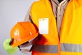 Worker in orange jacket outfit holding helmet closeup Royalty Free Stock Photo