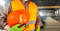 Worker in orange jacket outfit holding helmet Royalty Free Stock Photo