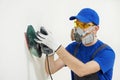 Worker with orbital sander at wall filling Royalty Free Stock Photo