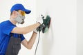 Worker with orbital sander at wall filling Royalty Free Stock Photo