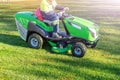 Worker in overalls clothes cutting the lawn driving professional mower Royalty Free Stock Photo