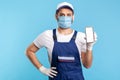 Worker in overalls and gloves holding mobile phone with blank display, device mock up for order app
