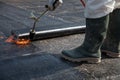 A worker overlay the roofing material on the flat concrete surface