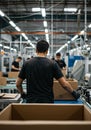 Worker packing boxes in a modern factory setting Royalty Free Stock Photo