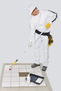 Worker paint primer tiles floor roller Royalty Free Stock Photo