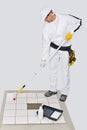 Worker paint primer tiles floor roller