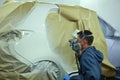 Worker painting a car.