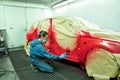 Worker painting a car.