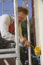 Worker painting house with roller