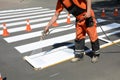 Worker is painting a pedestrian crosswalk. Technical road man worker painting and remarking pedestr