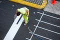 Worker painting a pedestrian crosswalk using paint sprayer gun Royalty Free Stock Photo