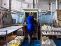 Worker is painting plastisol toys by paint sprayer in toy factory