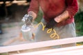 worker painting timber with spraygun, airgun. Carpentry details