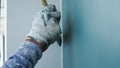 A worker is painting the walls of the house with a primer using a paint brush Royalty Free Stock Photo