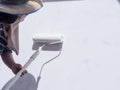 A worker is painting the walls of the house with a primer using a paint roller Royalty Free Stock Photo