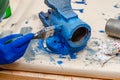 Worker paints a metal vise with blue paint. Stripping old paint