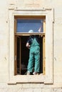 Worker paints a wooden window frame in the Gatchina Palace.