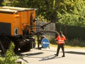 A worker patches holes in the asphalt of the driveway using special equipment. Road surface repair. Highway quality. Heavy road Royalty Free Stock Photo