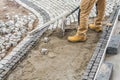 Worker Paving Residential Path Using Granite Bricks