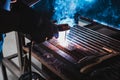 Worker perform electric metal welding in workshop class with a lots of spark. Focus on the equipment.