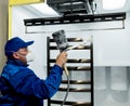 Worker performing powder coating of metal details at metallurgical factory Royalty Free Stock Photo