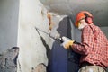 Worker with demolition hammer breaking interior wall Royalty Free Stock Photo