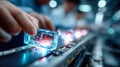 Worker placing a glowing technological module on an automated assembly line in a modern electronics factory Royalty Free Stock Photo