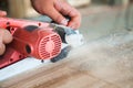 Worker planing a table top of wood with a electric plane Royalty Free Stock Photo