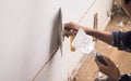 The worker is plastering the column with high quality white gypsum plaster to keep the joints together