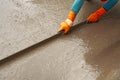 A worker plastering concrete on the floor