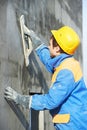 Worker at plastering facade work