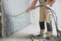 Plastering the interior wall with an automatic spraying plaster pump machine