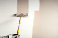Worker plastering a wall, painting with paint brush decoration on interior walls Royalty Free Stock Photo