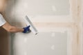 Worker plastering wall with putty knife indoors, closeup. Space for text Royalty Free Stock Photo