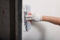 Worker plastering wall with putty knife indoors, closeup Royalty Free Stock Photo