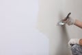 Worker plastering wall with putty knife indoors, closeup. Space for text Royalty Free Stock Photo